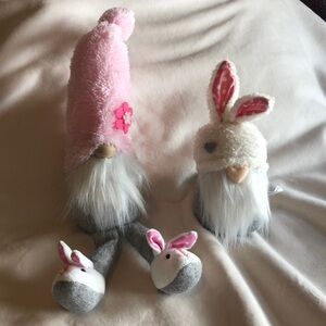 2 gray and pink stuffed gnomes.